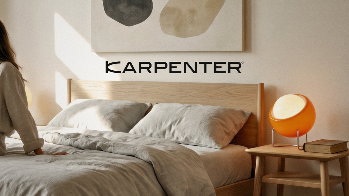 Karpenter solid oak bed with matching bedside table and warm ambient lighting in a minimalist bedroom setting