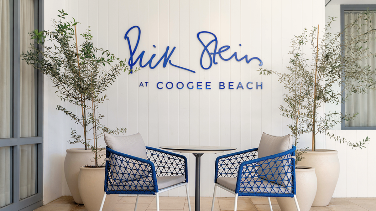 Rick Stein at Coogee Beach terrace with blue Mamagreen Ohana dining chairs and a round Glyph table.