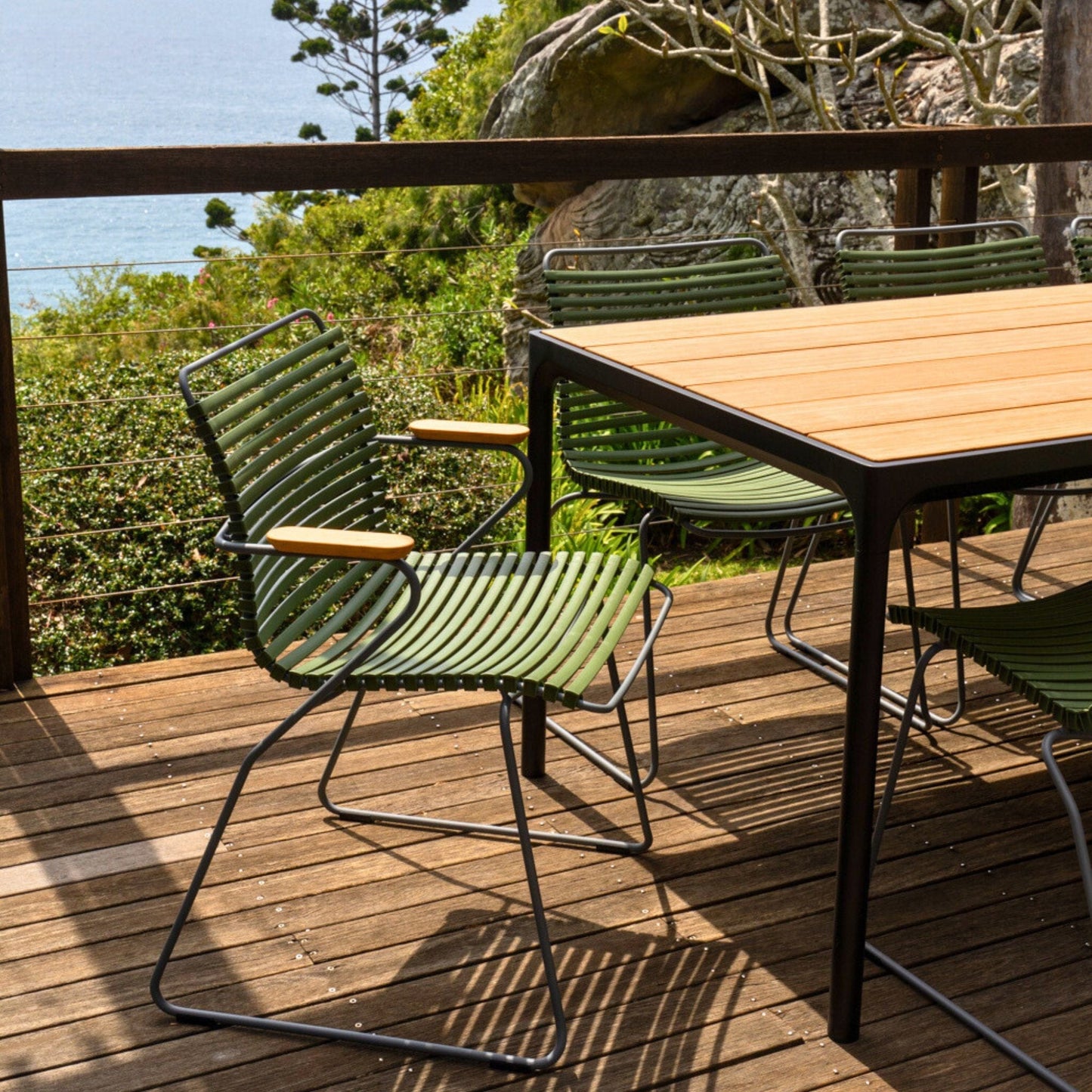 Green outdoor chair and table on a deck.