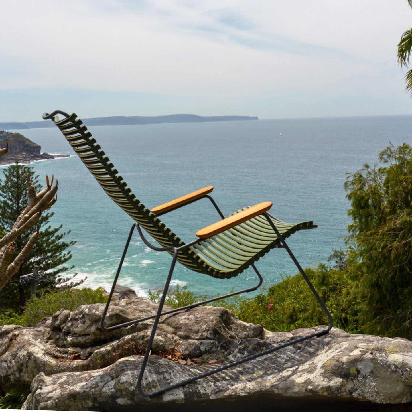 Lounge chair on a rock overlooking the ocean.