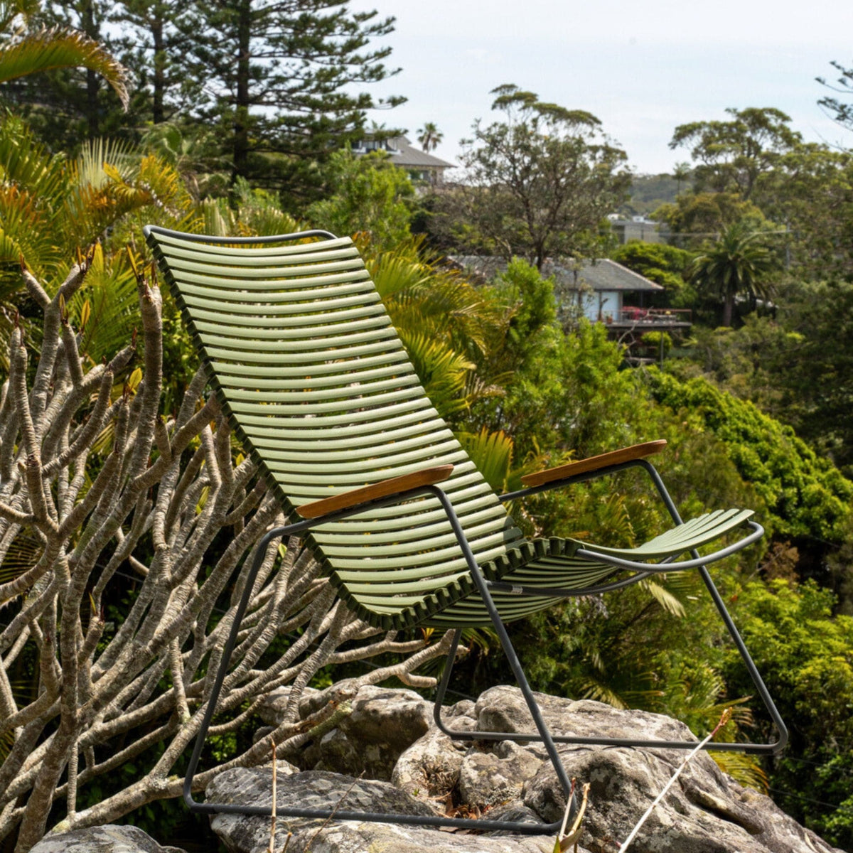 Green outdoor chair on a rock.