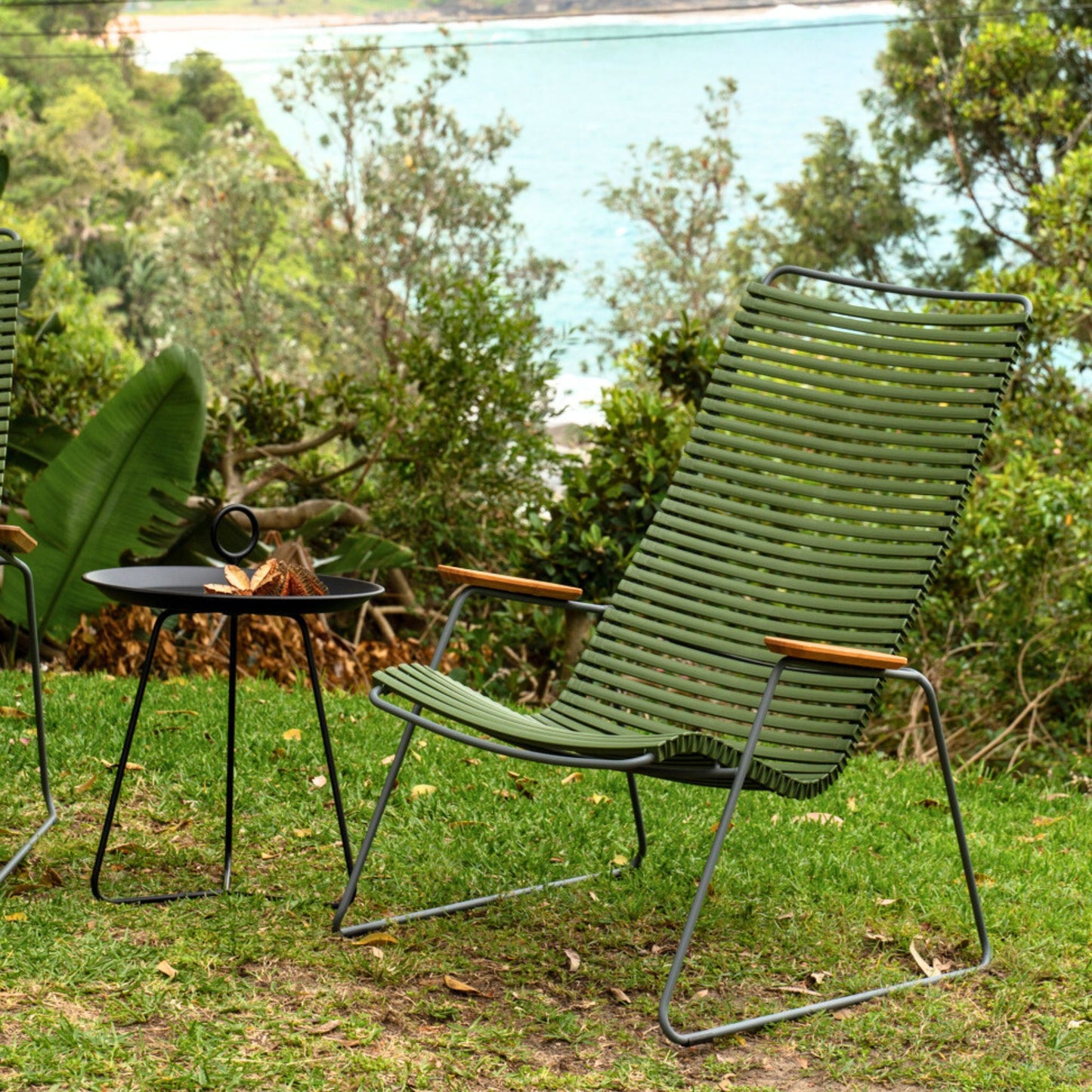 Green outdoor chair and table on grass.