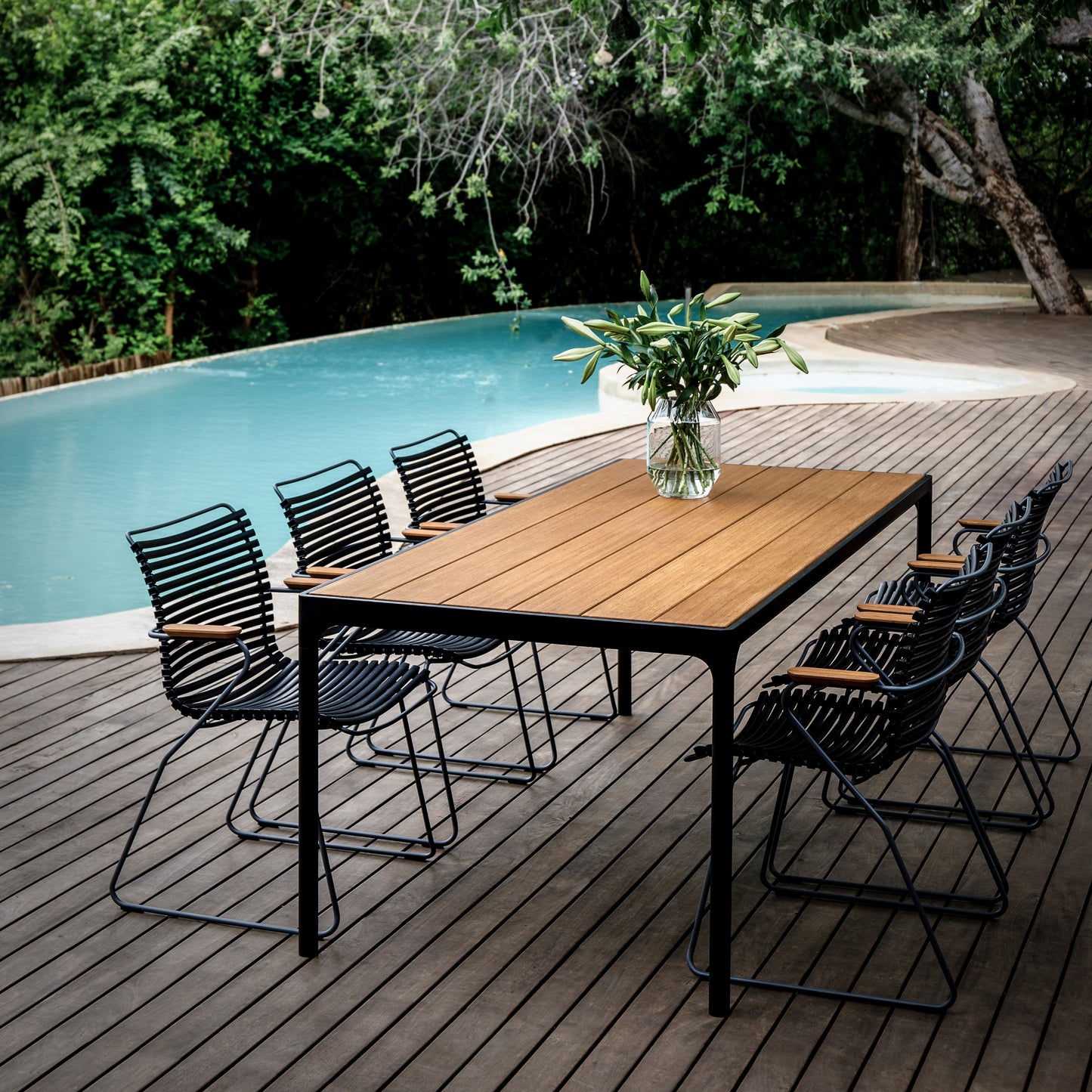 Outdoor dining table and chairs by a pool.