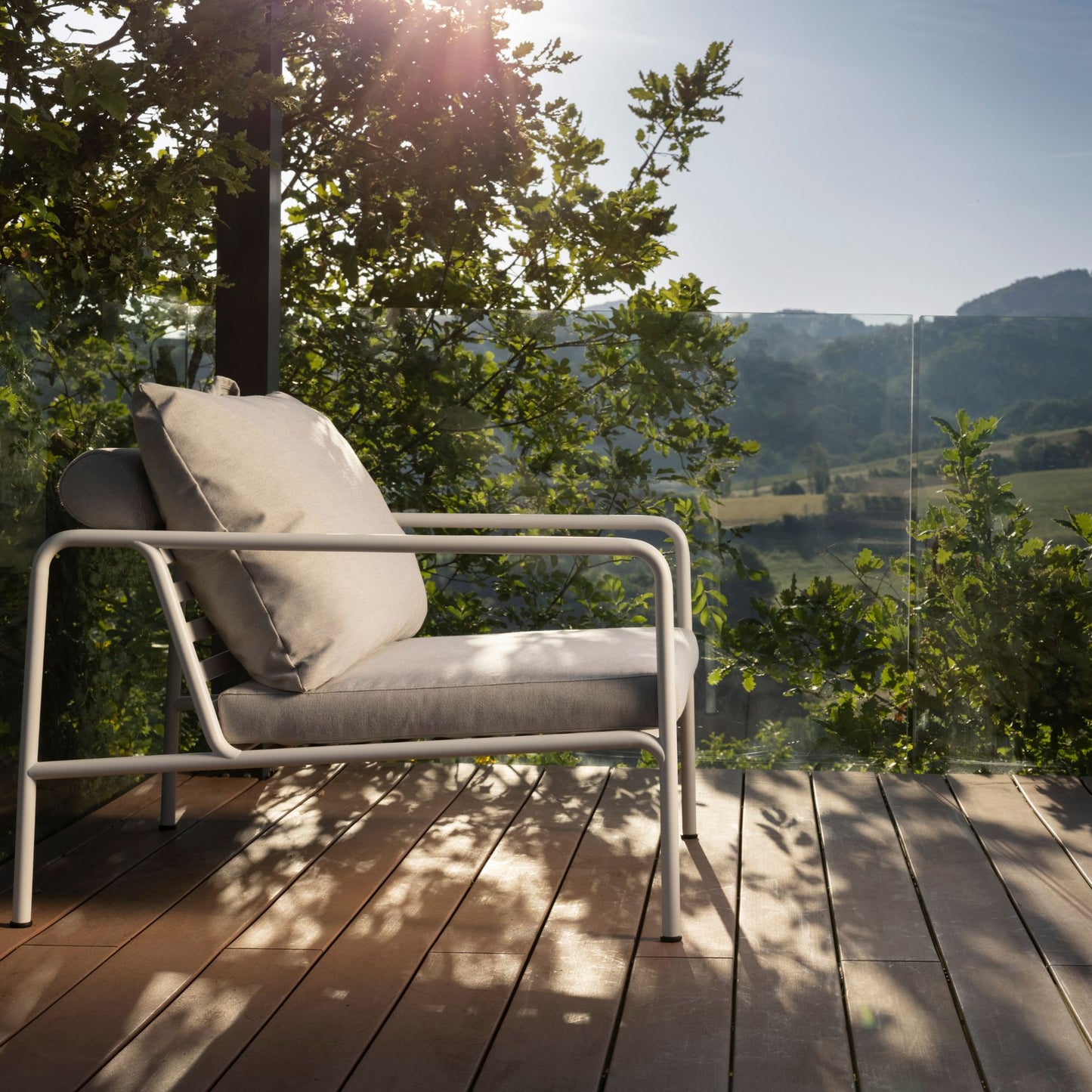 Chair on a wooden deck overlooking a landscape.