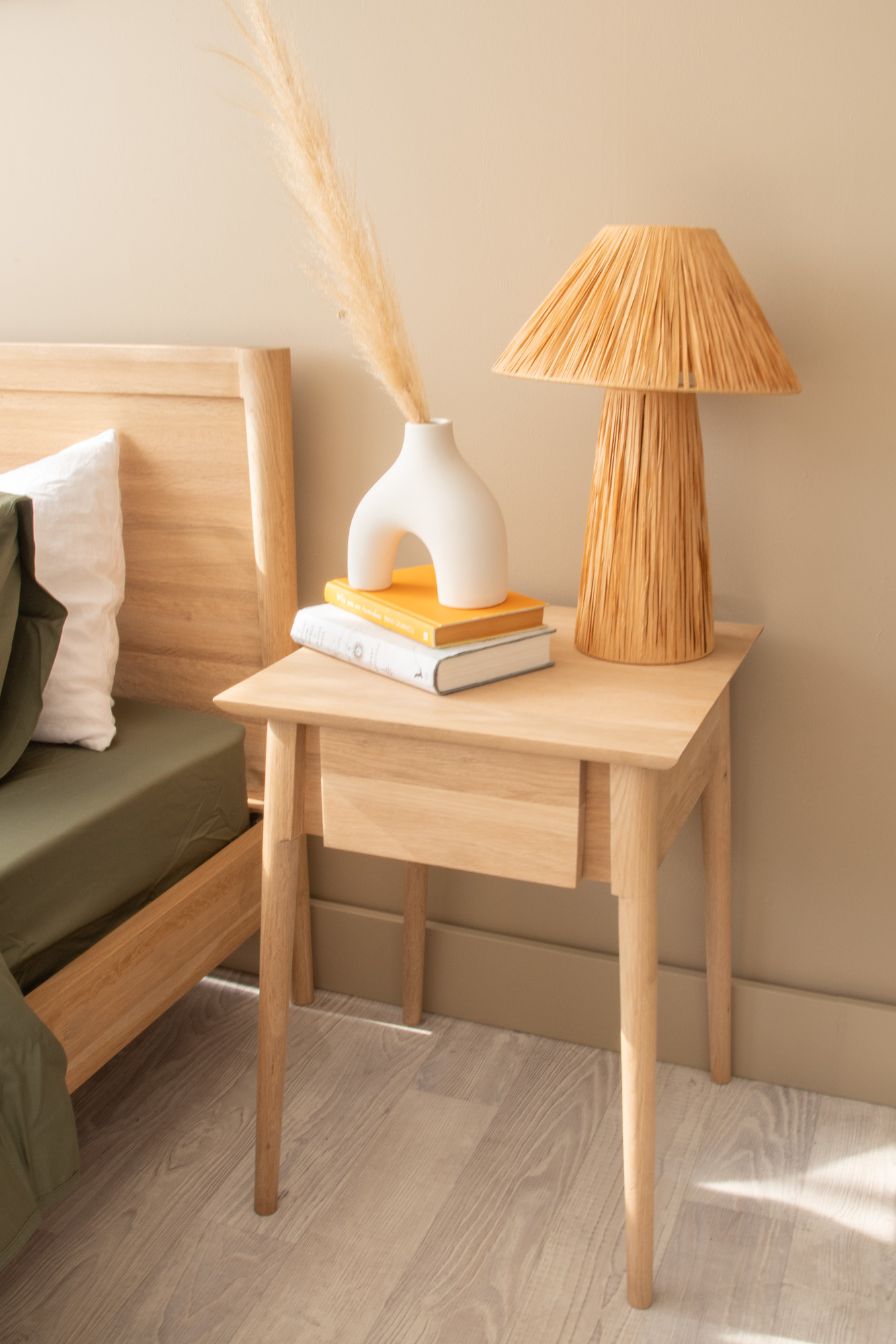 Nightstand with lamp, books, and vase - c53ccd09