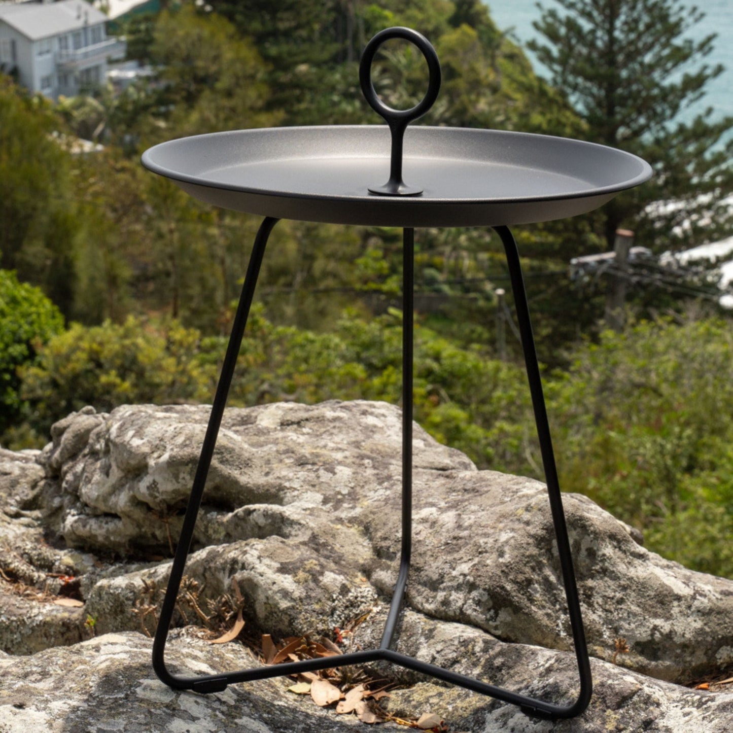 Black metal side table with handle.