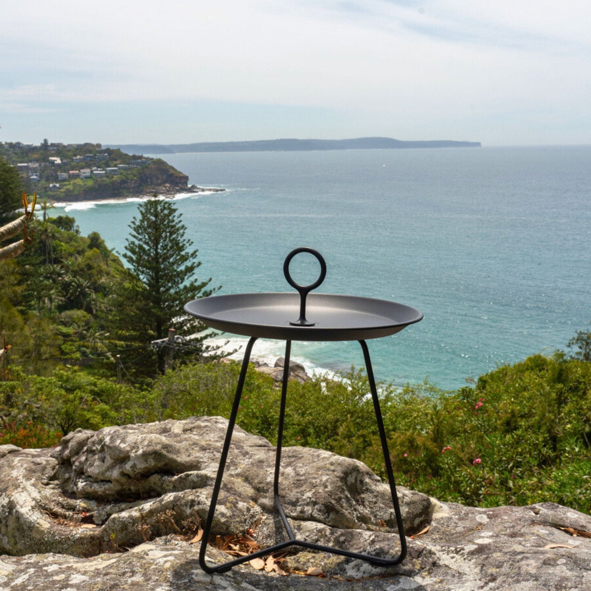 Black side table with handle overlooking the ocean.