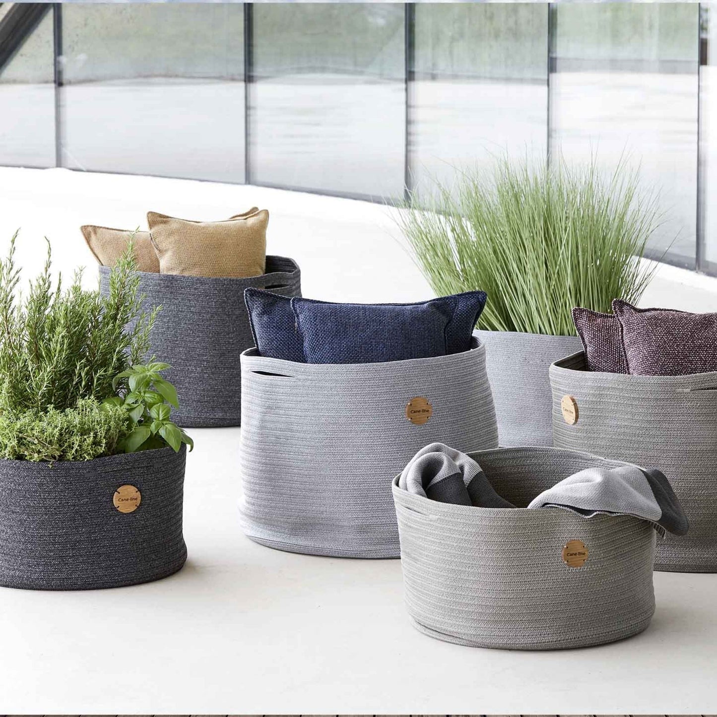 Decorative rope baskets with pillows and plants
