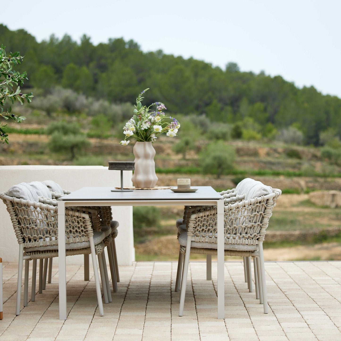 5417ROSA outdoor dining set with woven chairs and floral centerpiece