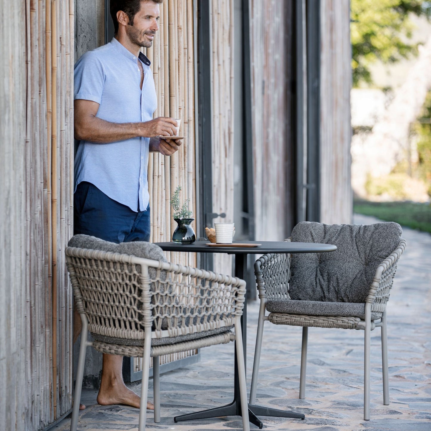 Man enjoying coffee at patio table with 5417ROT_2 chairs