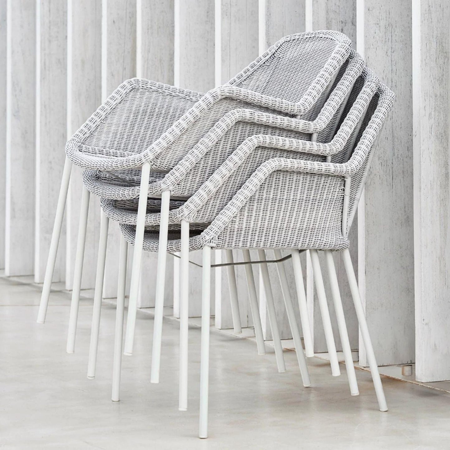5464LW_3 Stacked gray wicker chairs with white legs