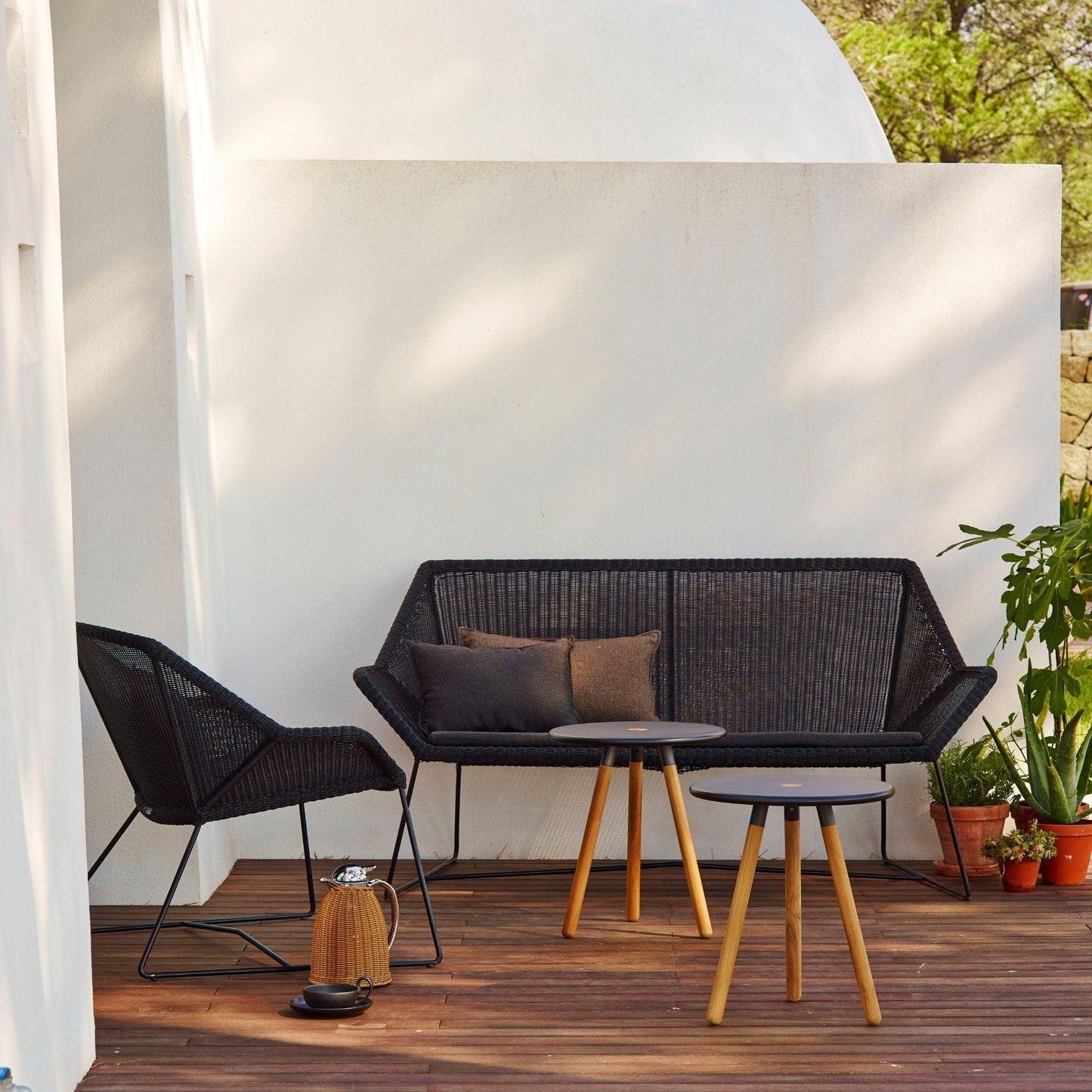 Black outdoor furniture set with sofa, chair, and side tables