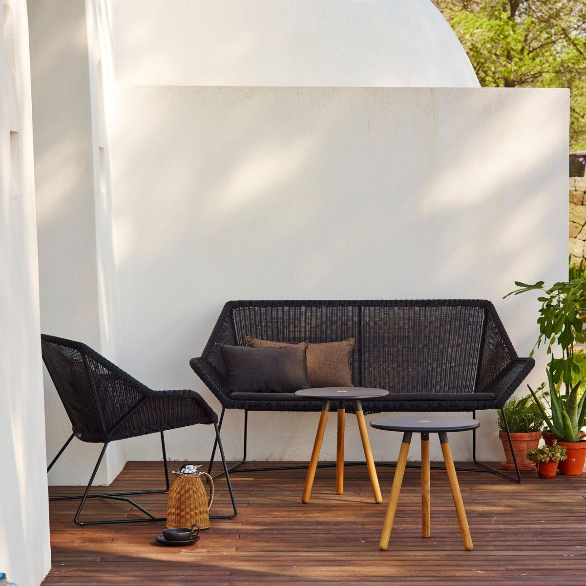 Black outdoor furniture set with sofa, chair, and side tables