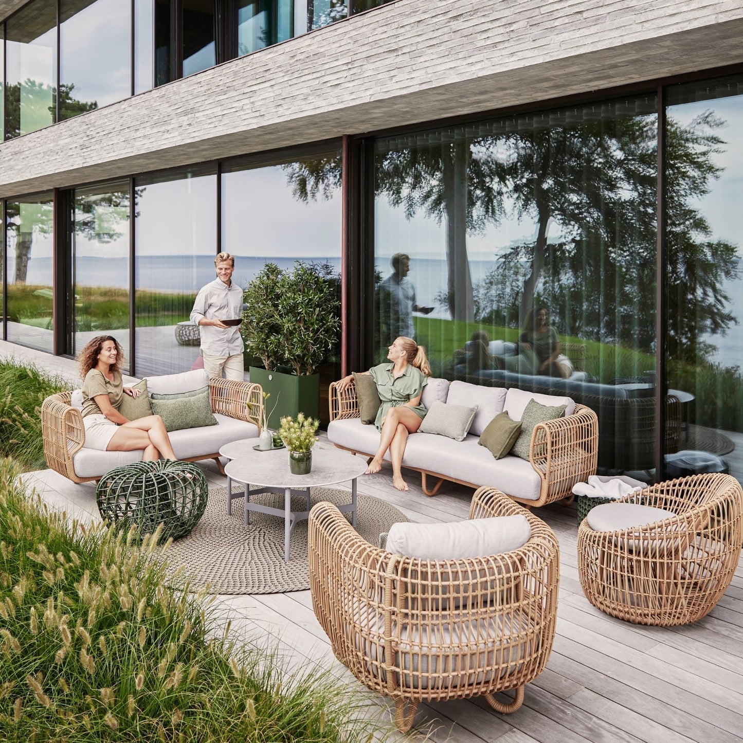 57421USL_8 Outdoor rattan furniture set with people, waterside view