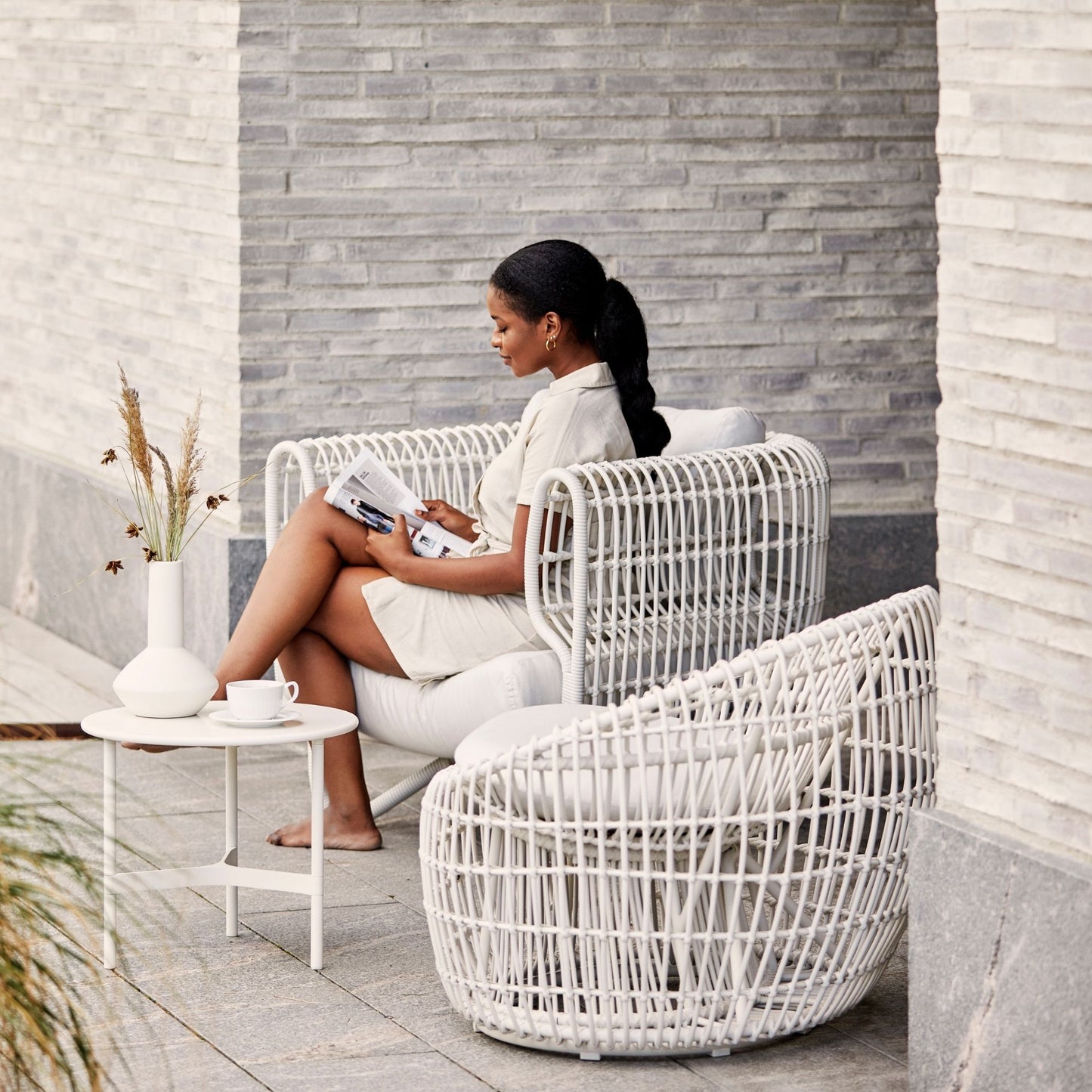 Woman reading in 57422WSW_2 white wicker chair