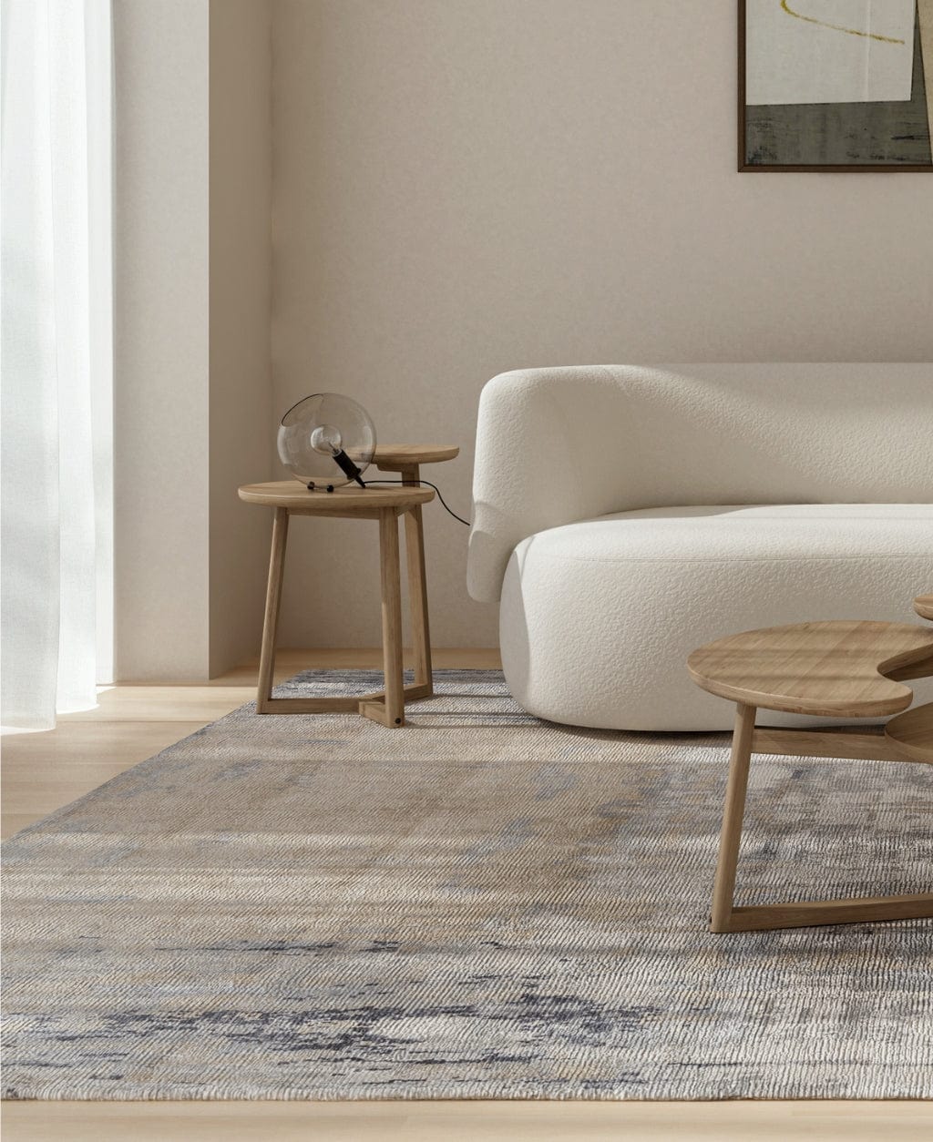 Living room with sofa, rug, and side tables.