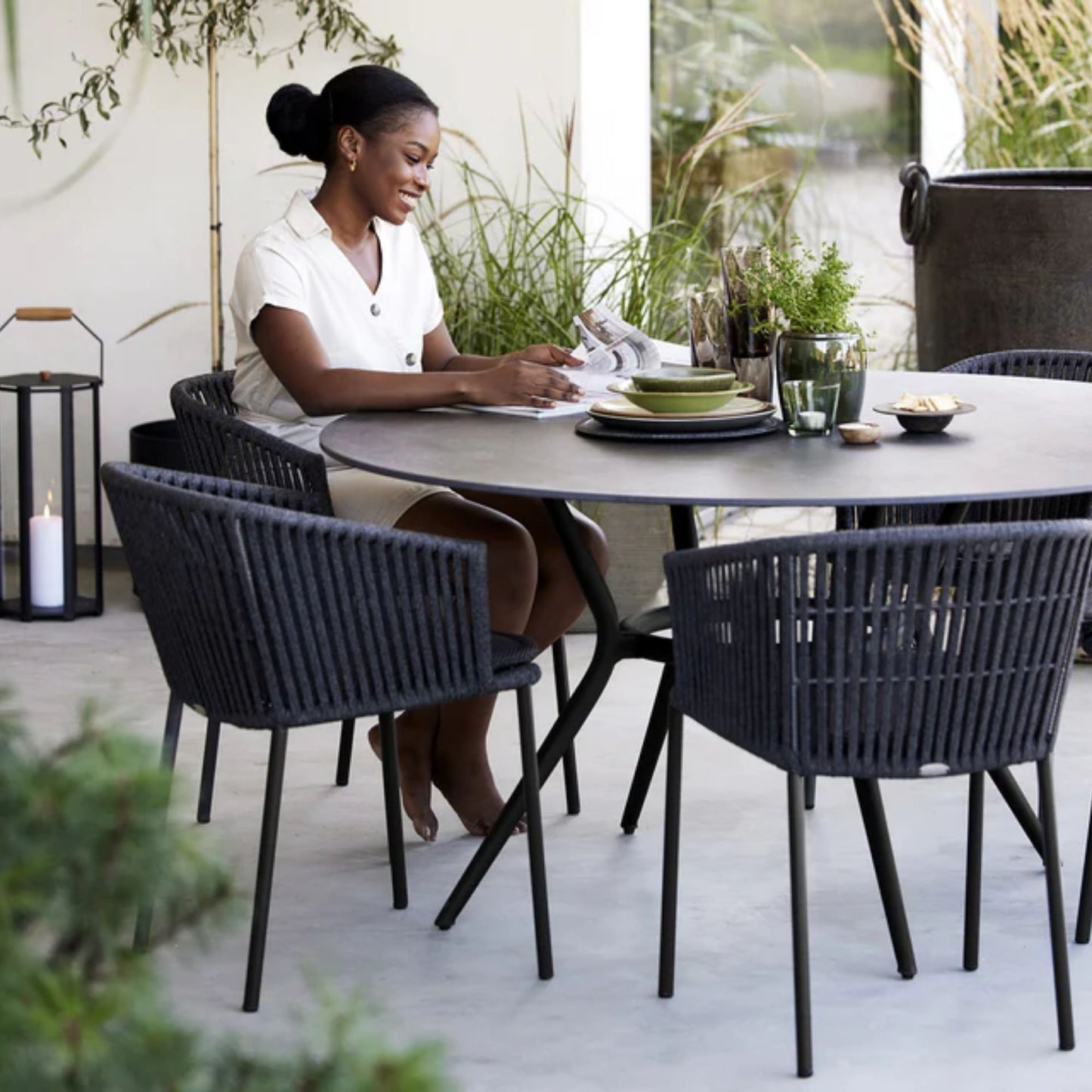 Woman at outdoor dining table with chairs