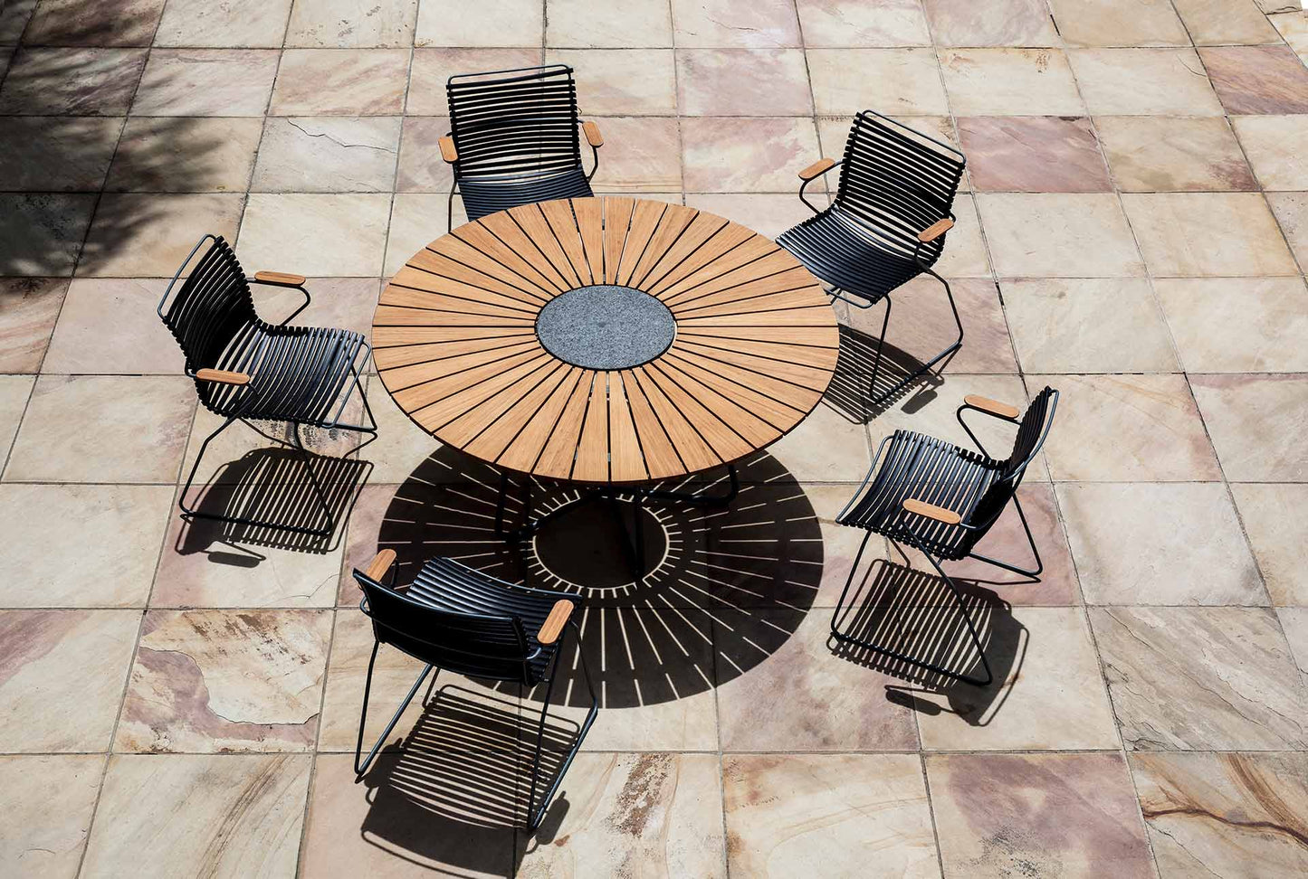 CLICK Dining set with black chairs around a wooden table.