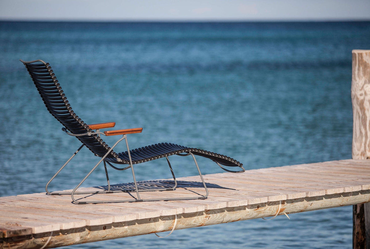 Black HOUE CLICK sunlounger on a pier overlooking the ocean.