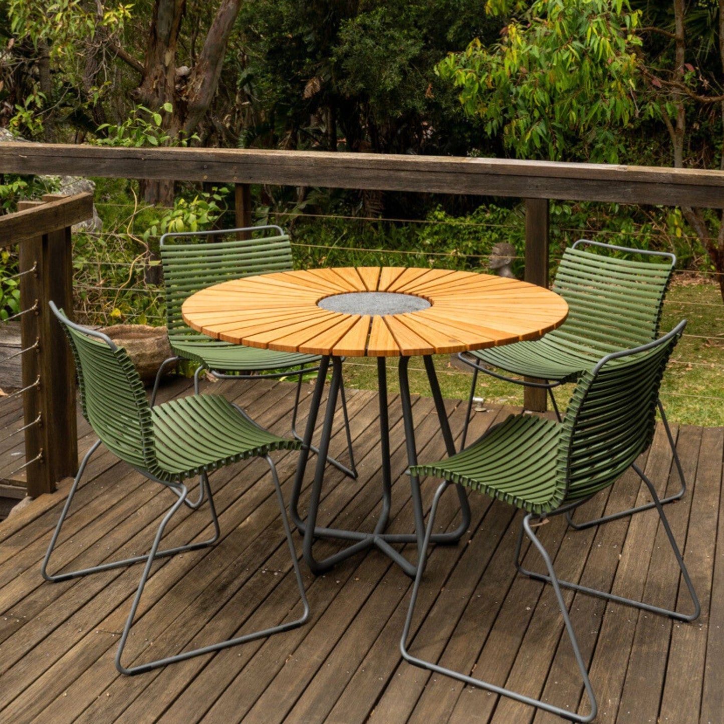 Round table with green chairs on deck