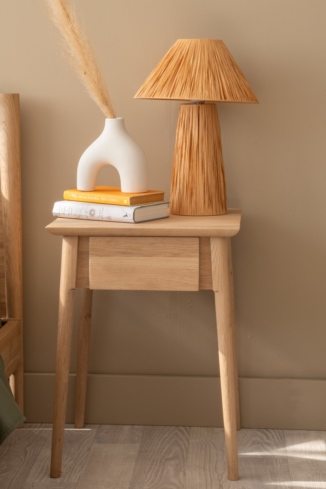 Nightstand with lamp, vase, and books
