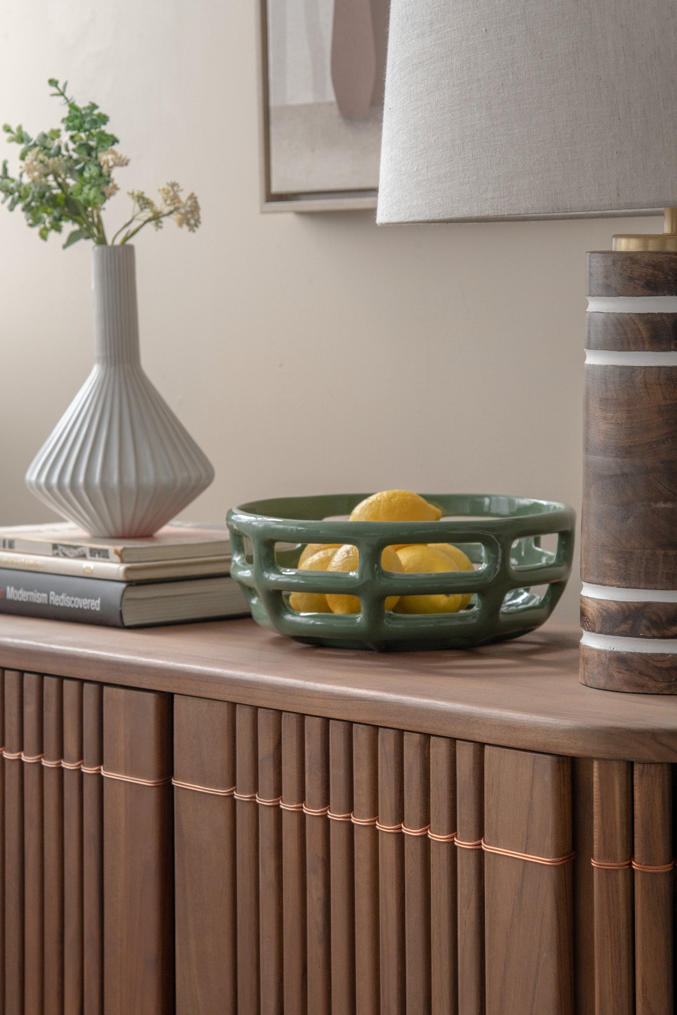 Green ceramic bowl with lemons on wooden console