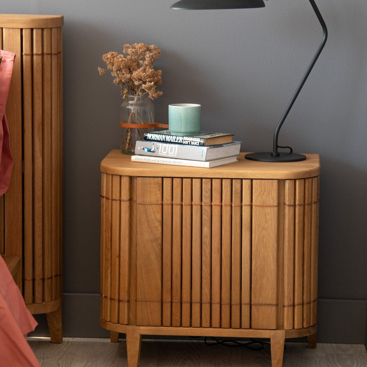 Wooden nightstand with lamp, books, and vase - DSC_2133