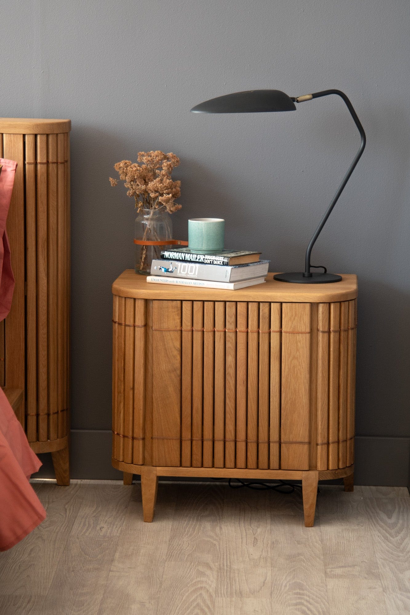 Wooden nightstand with lamp, books, and vase - DSC_2133