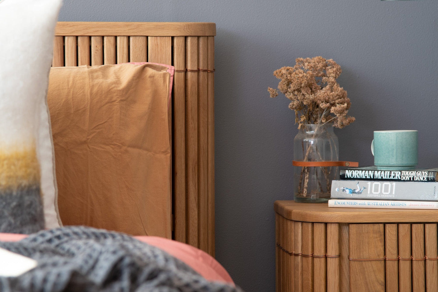 Wooden bed frame and nightstand with decor.