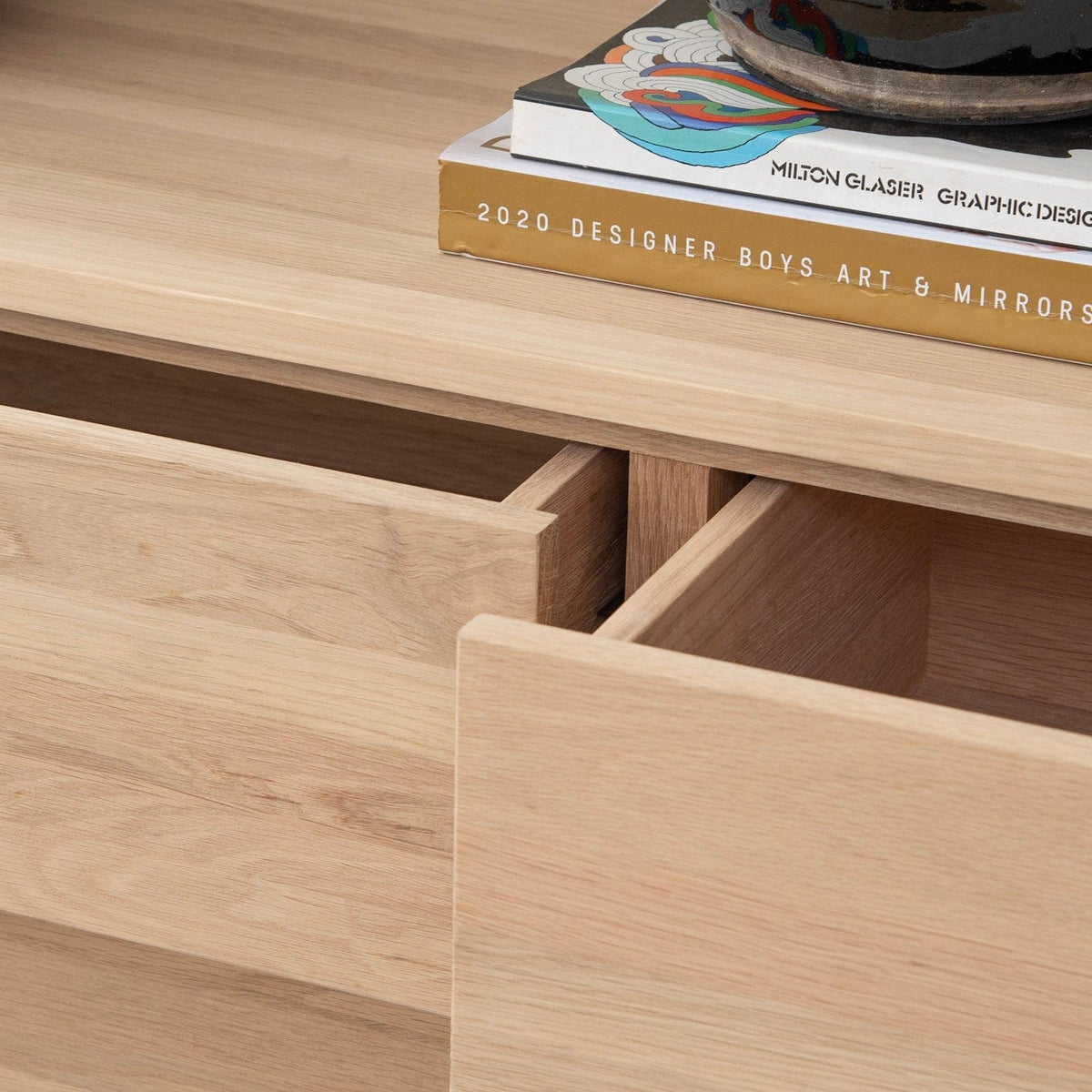 Open wooden cabinet drawers with books and decor