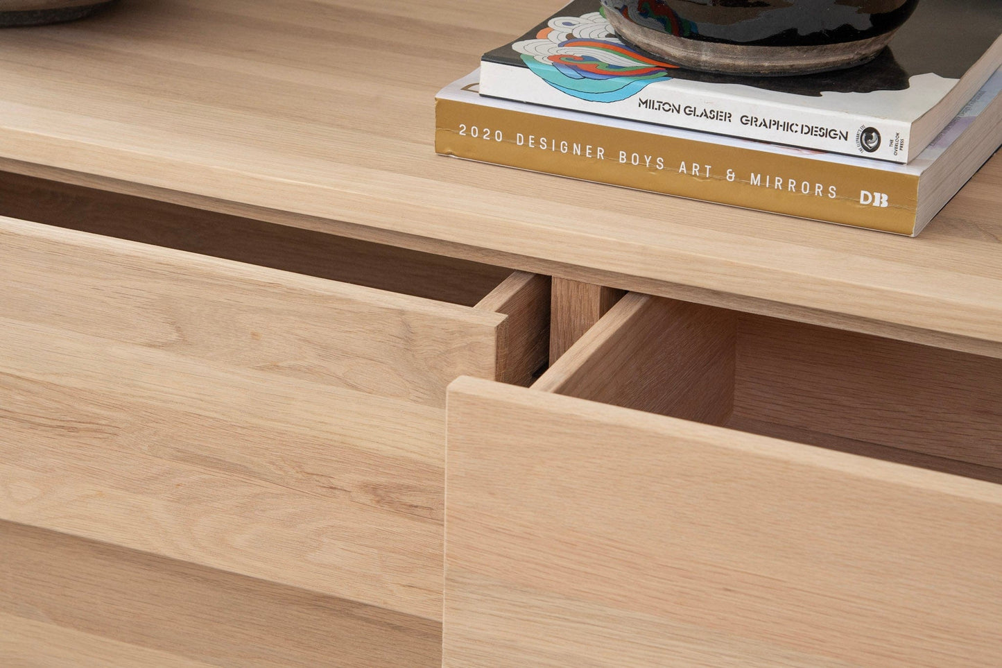 Open wooden cabinet drawers with books and decor