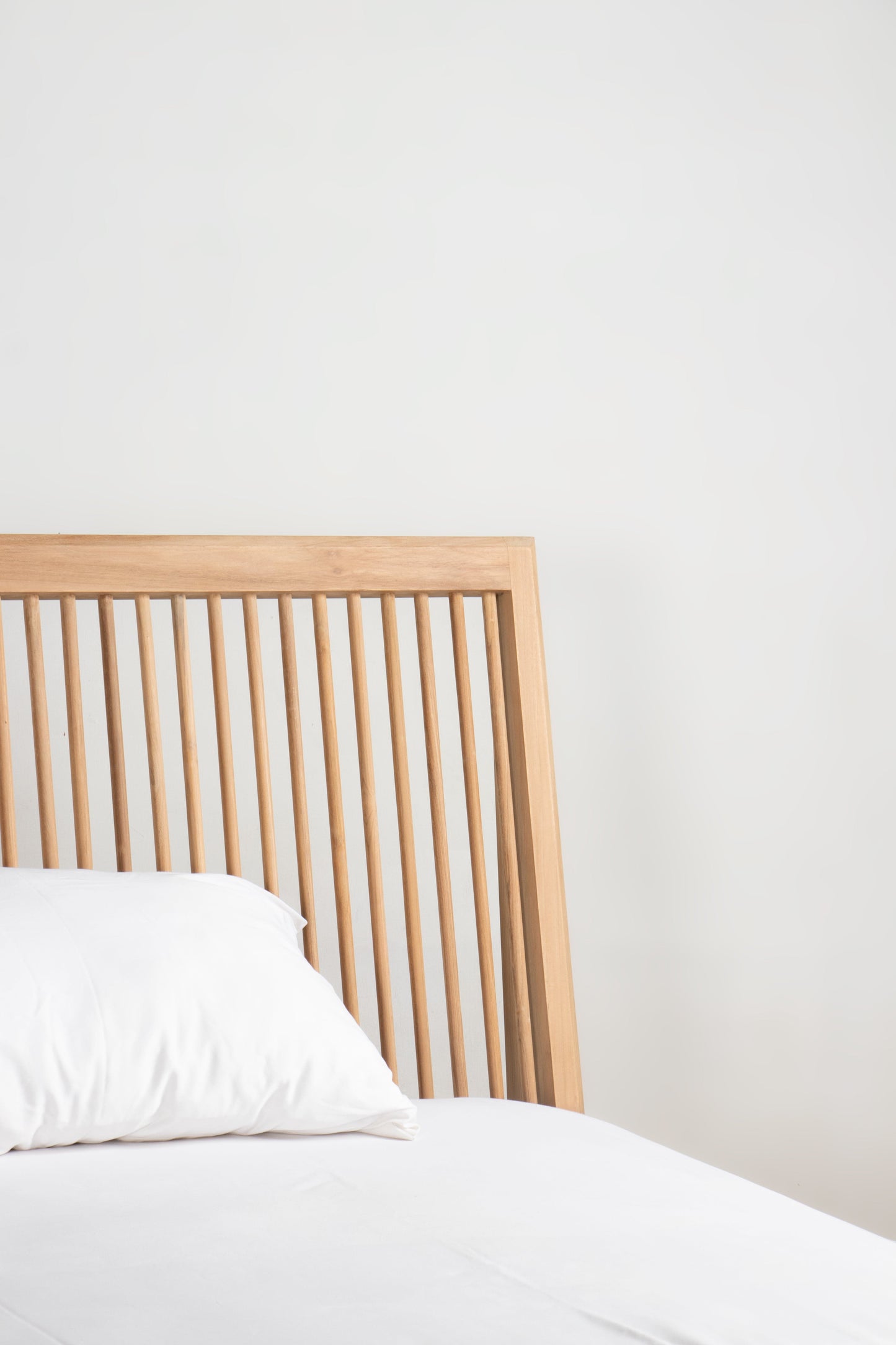 Detail of Jodoh Bed Frame with white pillow and headboard