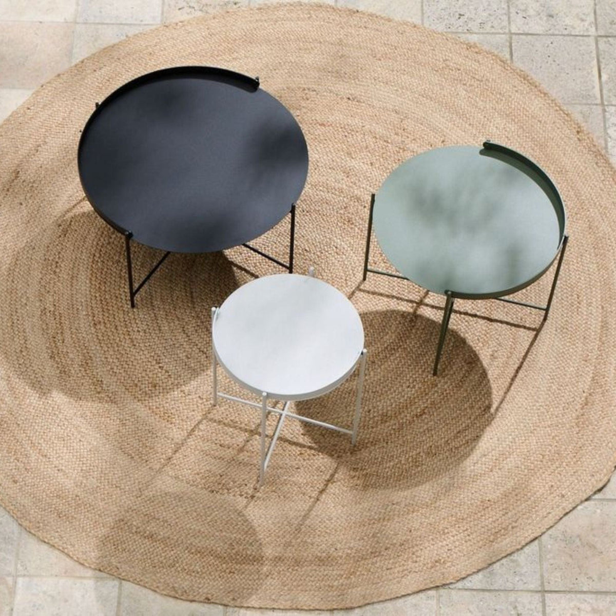 Three modern side tables on a round rug