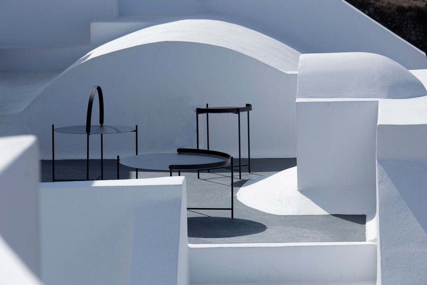 EDGE Black HOUE tables in 3 sizes on white steps
