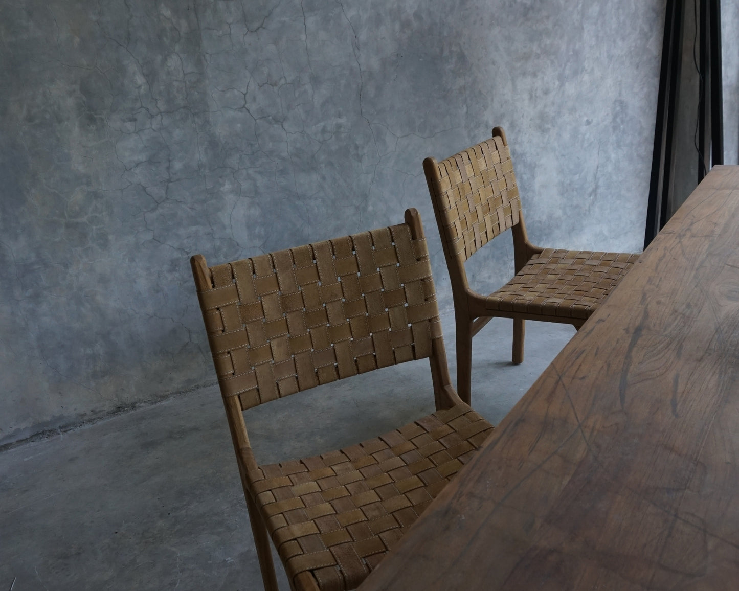 Two woven-back chairs at a wooden table