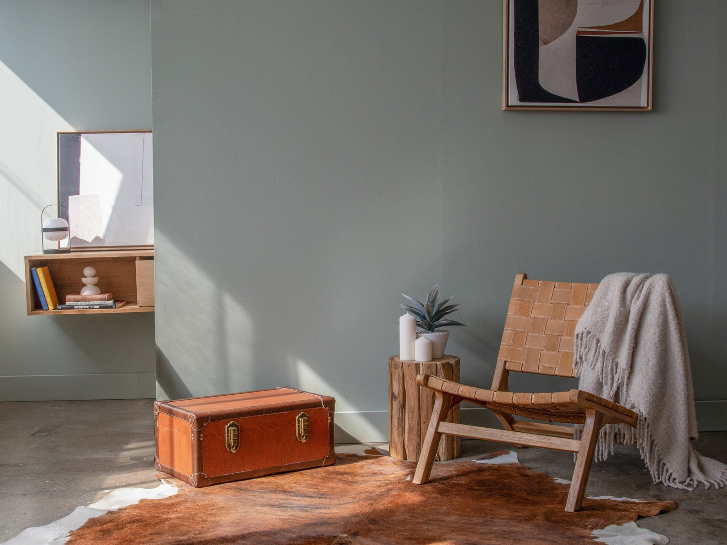 Interior design with trunk, chair, and wall art.