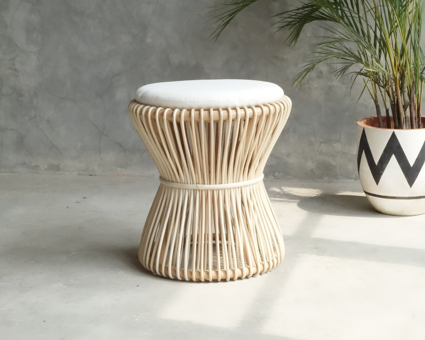 Woven rattan stool with white cushion