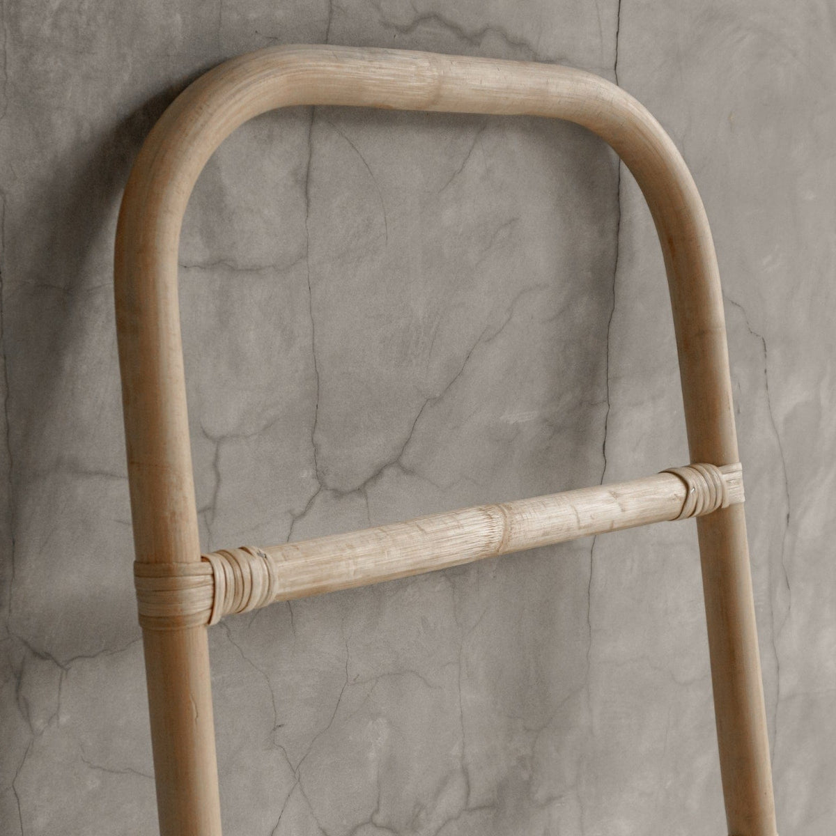 Close-up of a wooden ladder against a textured wall