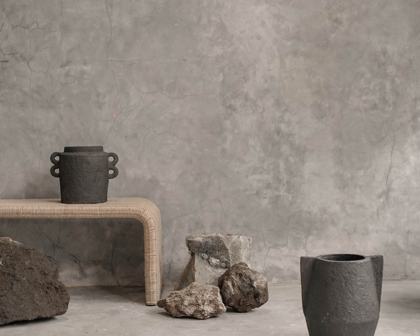Gray pottery and stone display on concrete surface