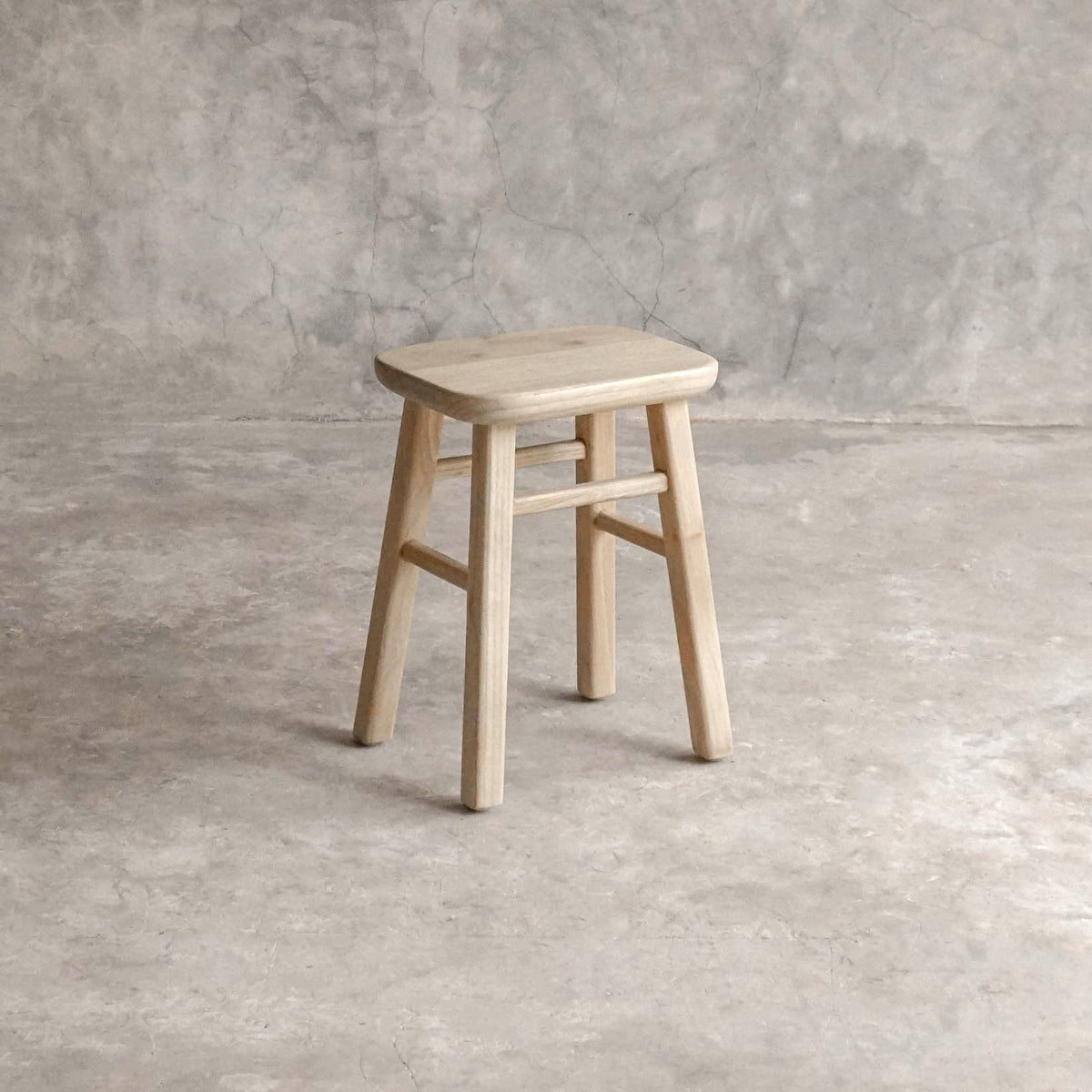 ELE143-1 wooden stool against a textured wall