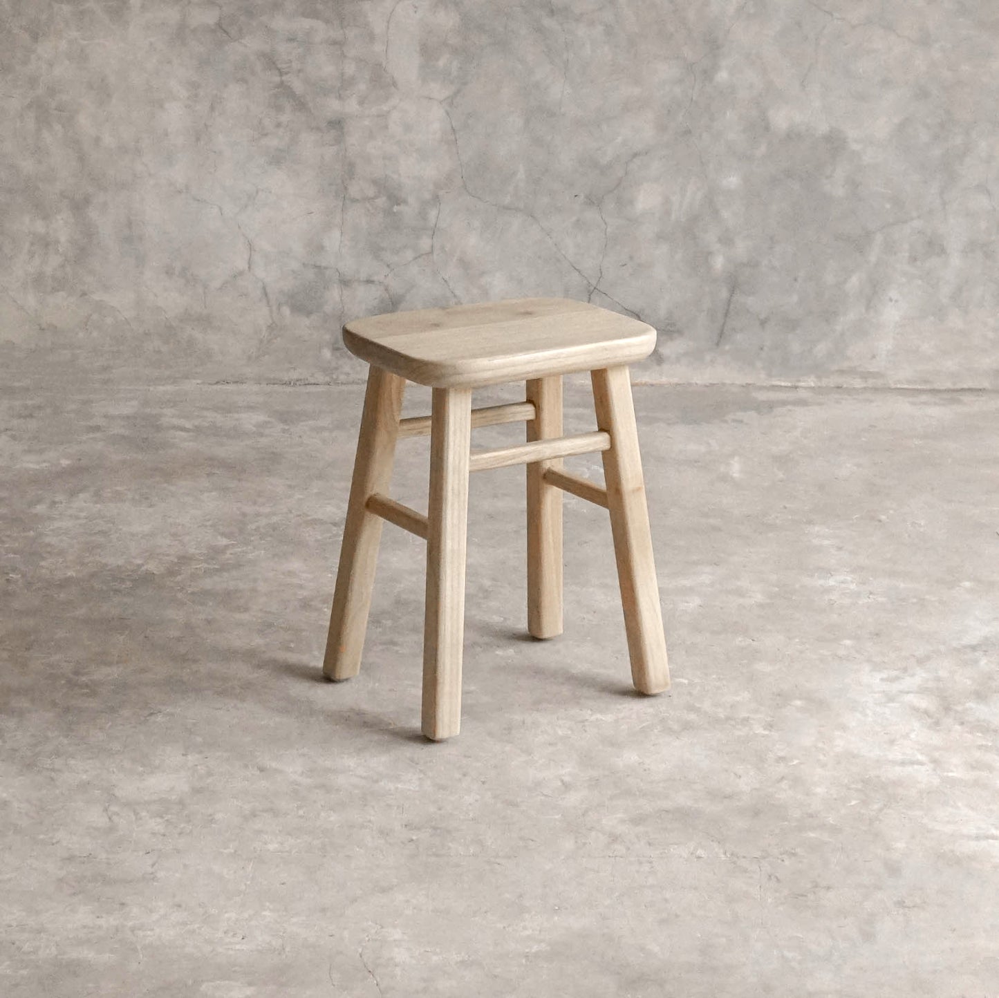 ELE143-1 wooden stool against a textured wall