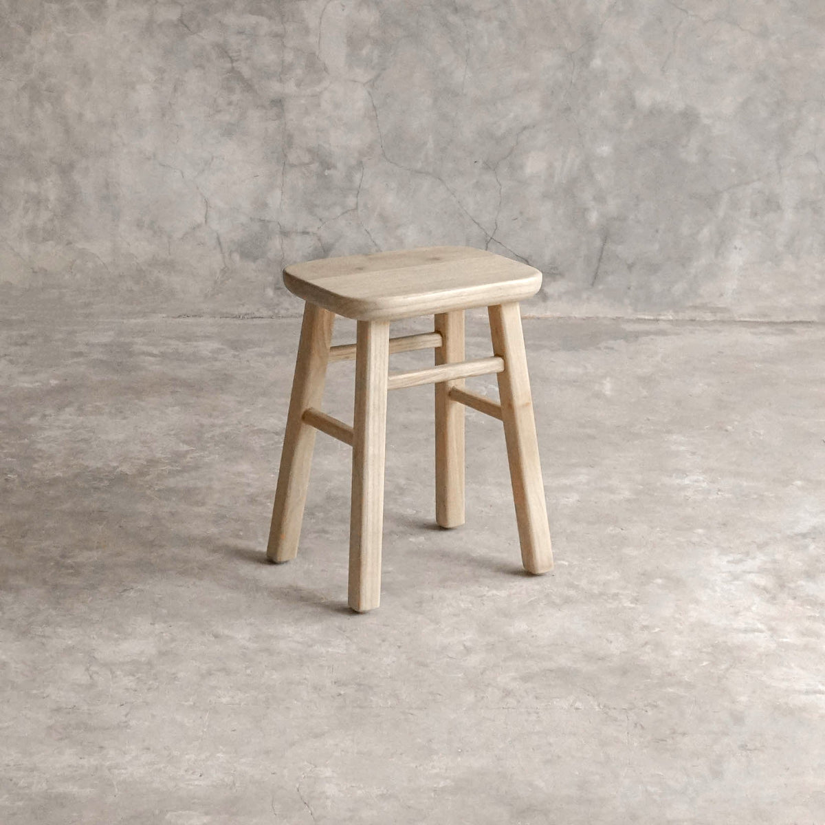 ELE143-1 wooden stool against a textured wall