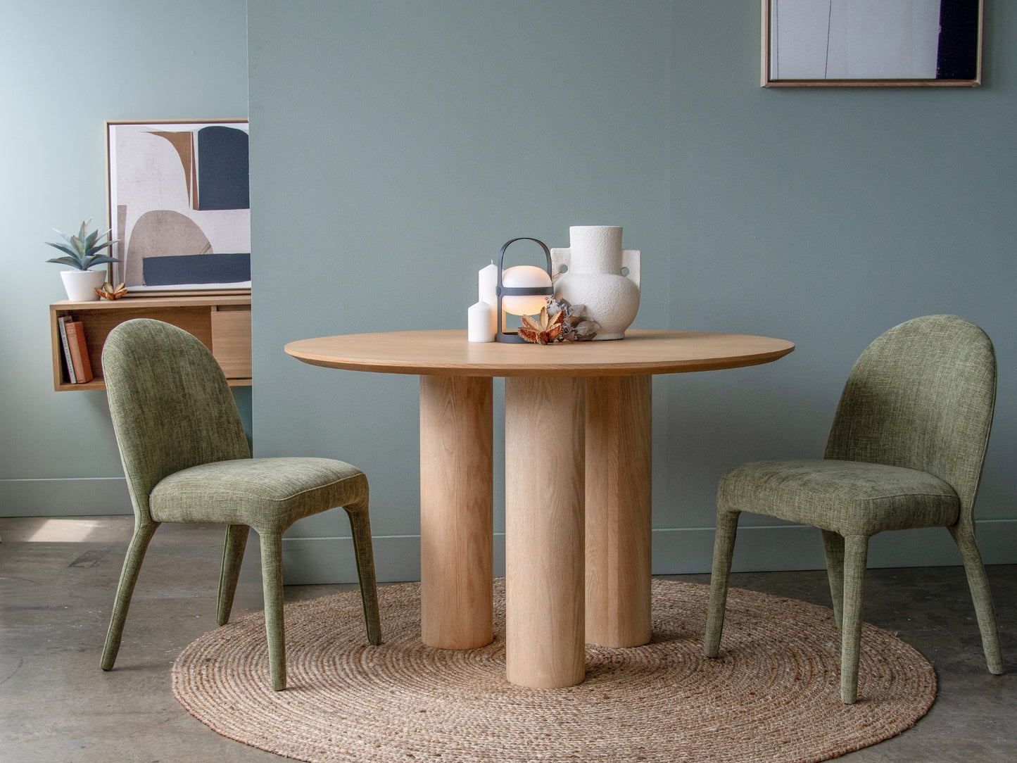 Round wooden dining table with green chairs