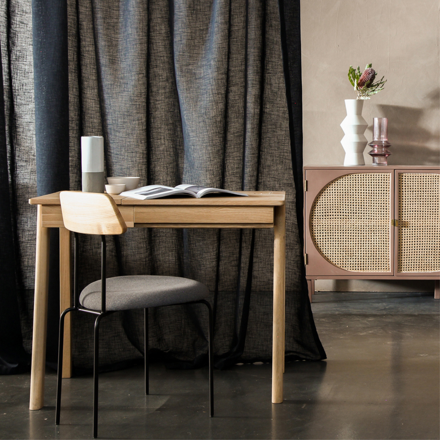 Modern home office setup with wooden desk, chair, and decor.