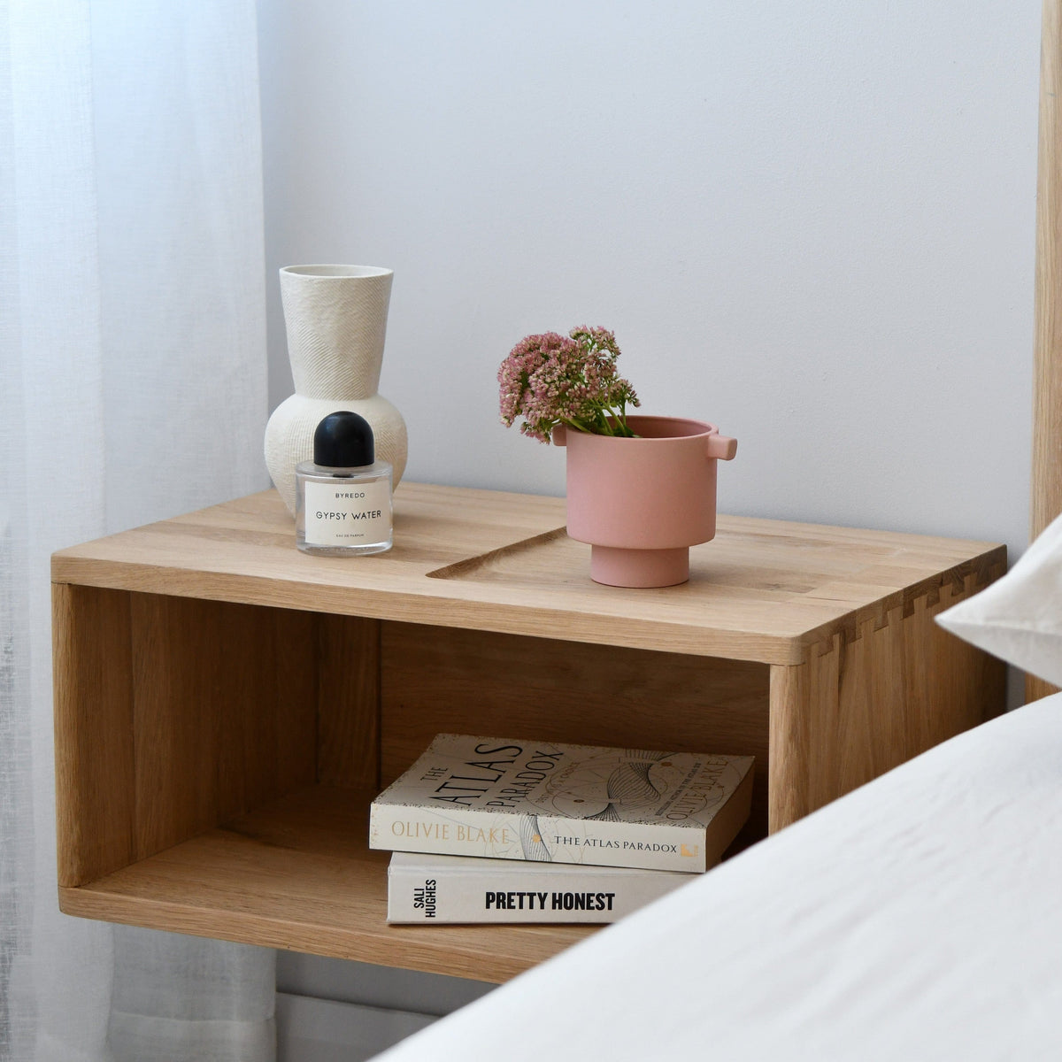 Wooden bedside table with decor and books