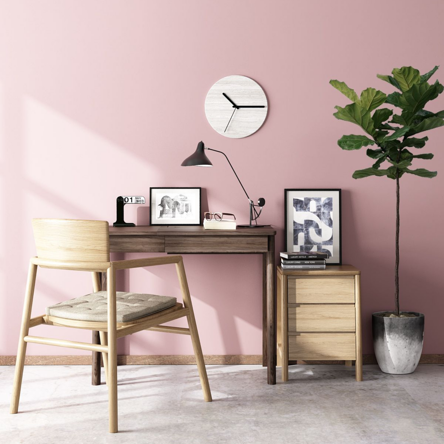 Pink office desk with chair, clock, and plant.