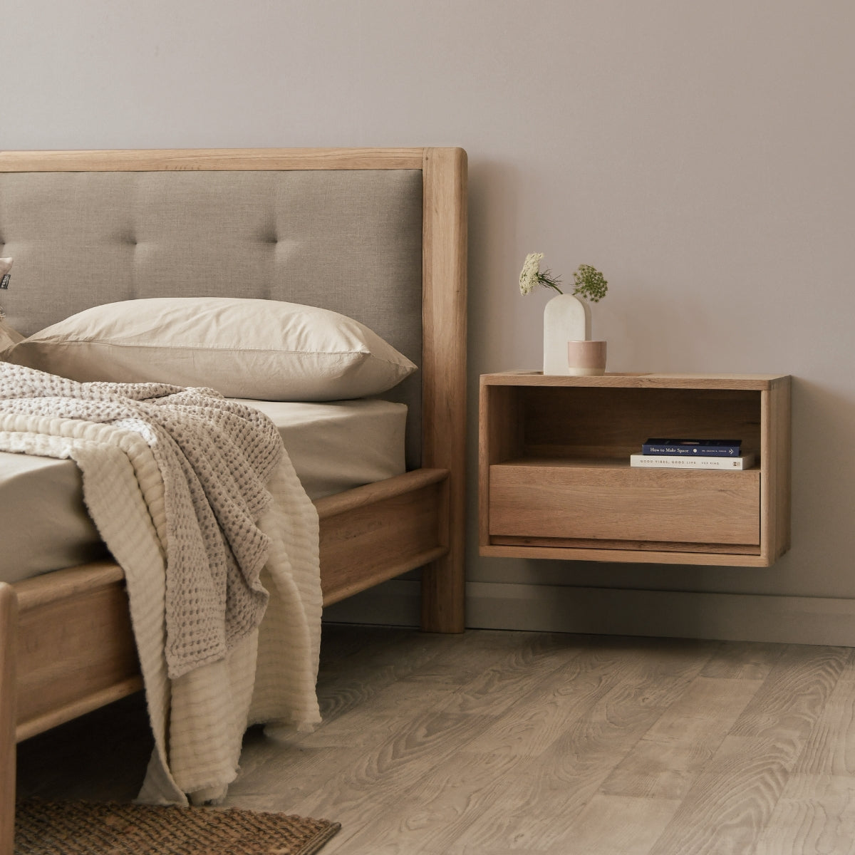 Wooden bed with upholstered headboard and matching nightstand in a bedroom setting.