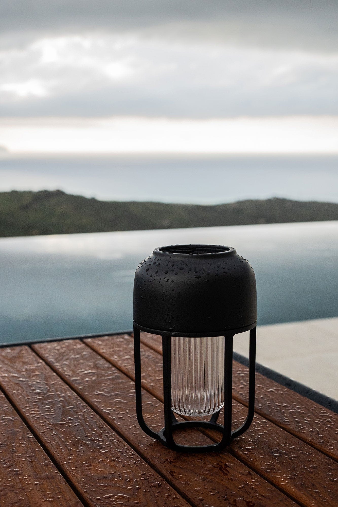 Black outdoor rain lamp on wooden table