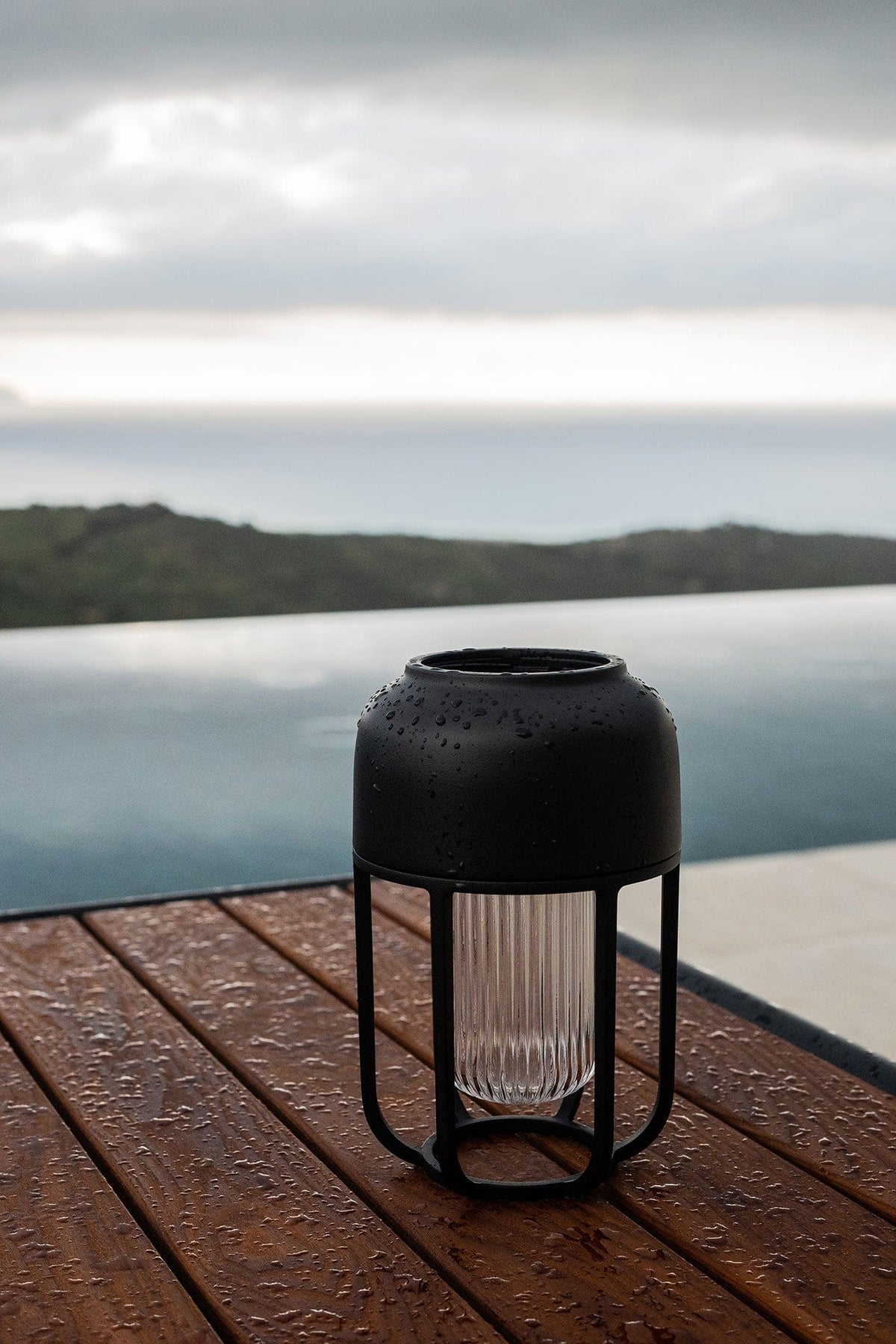 Black outdoor rain lamp on wooden table