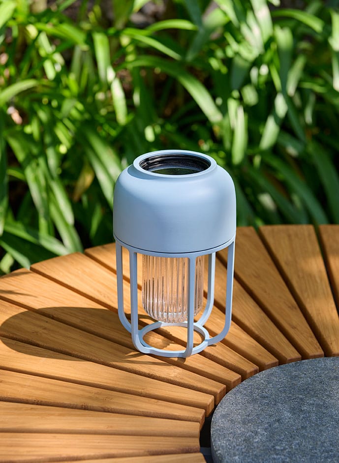Ice blue solar lantern on a wooden circle